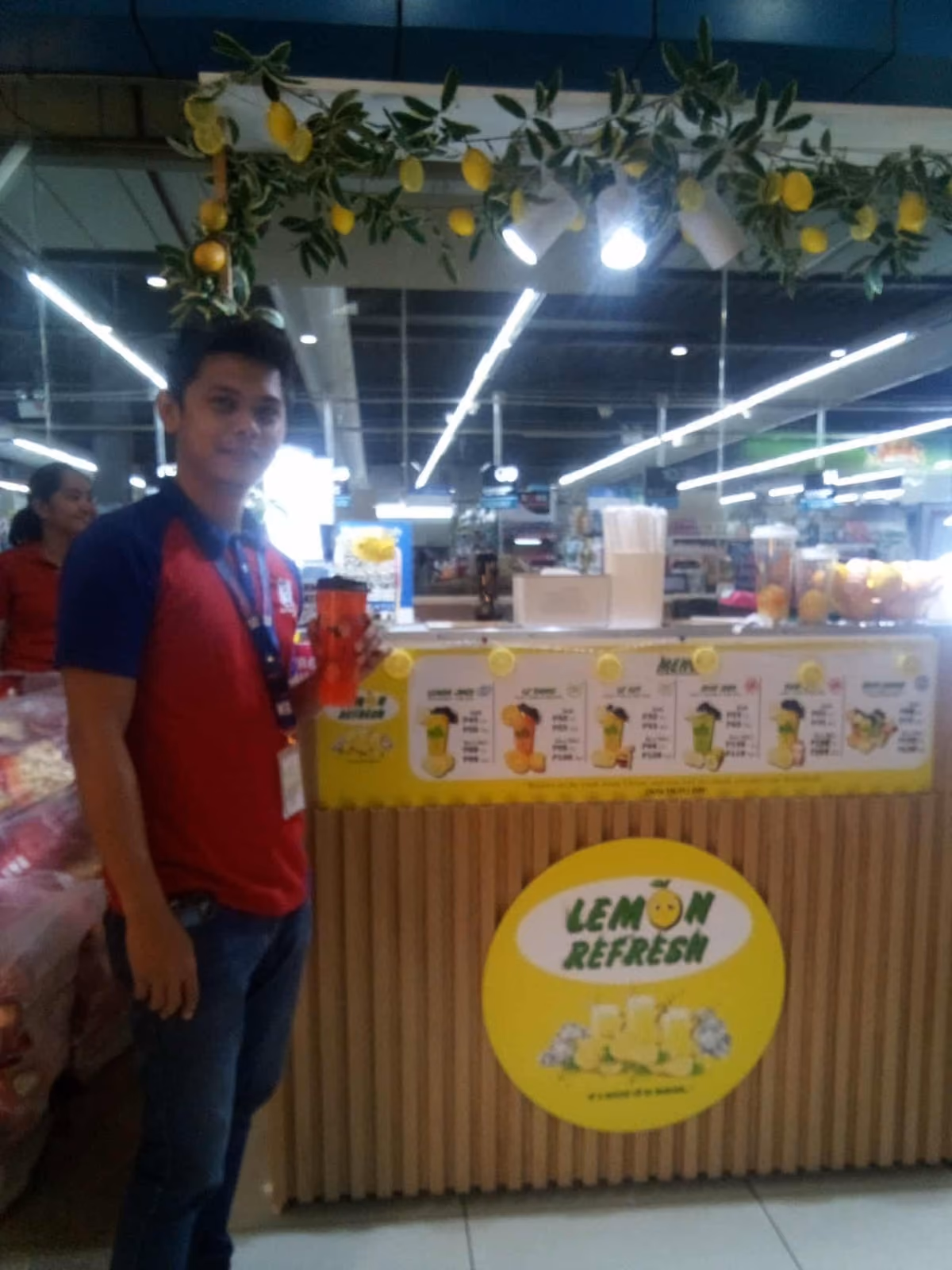 A customer beside the Lemon Refresh cart inside a store